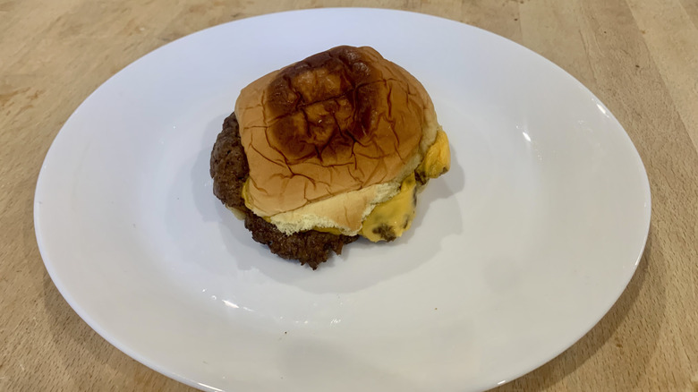 7th Street Burger burger on white plate on wood table