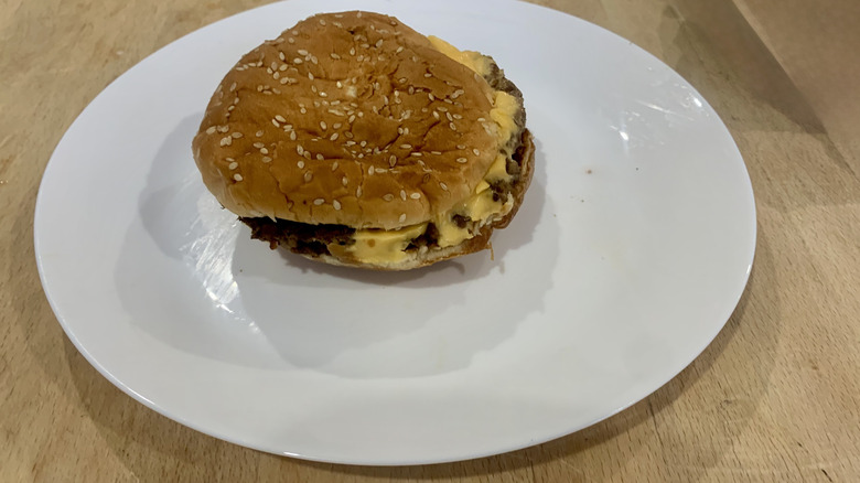 Five Guys burger on white plate on wood table