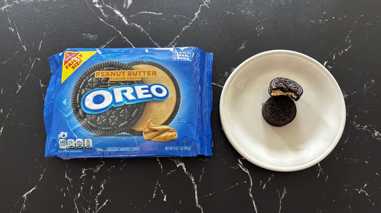 Peanut butter Oreos package next to Oreos on plate