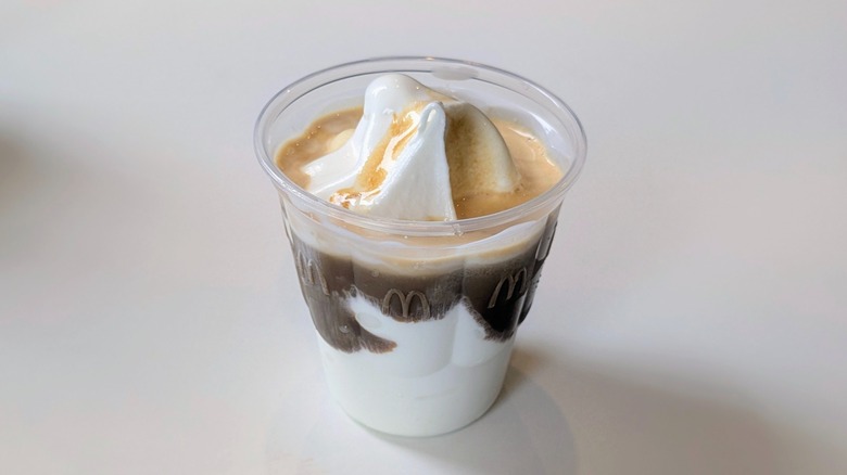 A cup of vanilla soft serve with espresso in it on a table at McDonald's