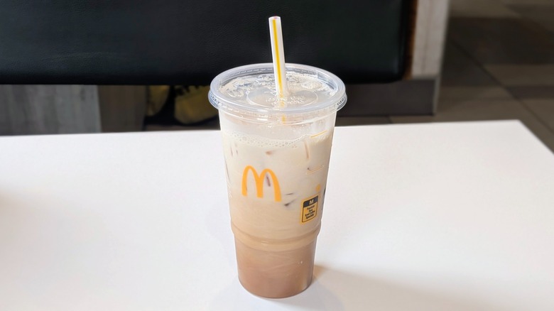 A sweet tea mixed with cream in a plastic cup on a table at McDonald's