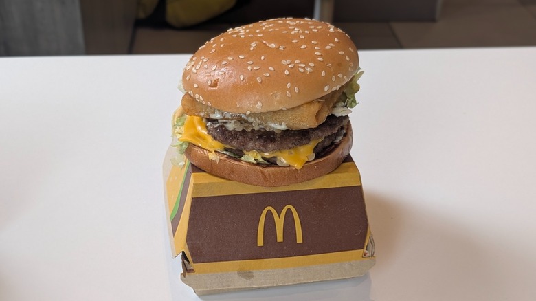 A Big Mac with a Filet-O-Fish patty on top of its box on a table at McDonald's