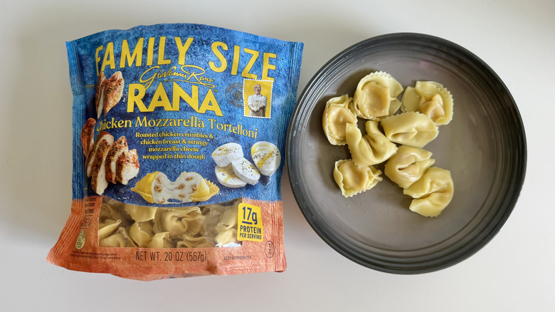 Chicken Mozzarella Tortelloni package on a table with some pieces on a plate next to it