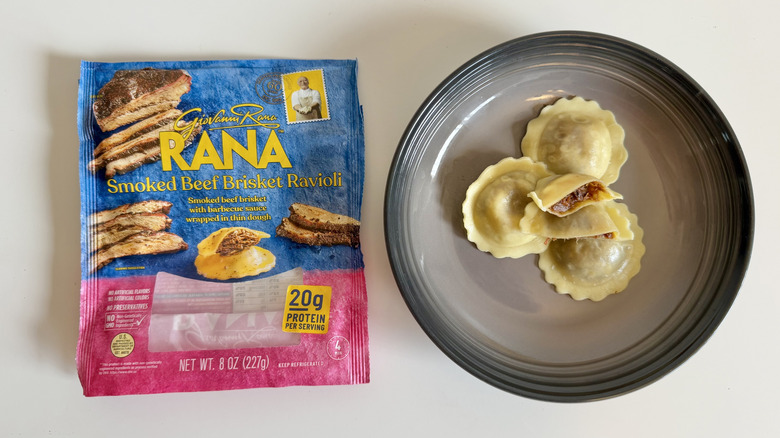 Rana Cooked Smoked Beef Brisket Ravioli pieces in a plate with one piece sliced in half and the whole box on the side