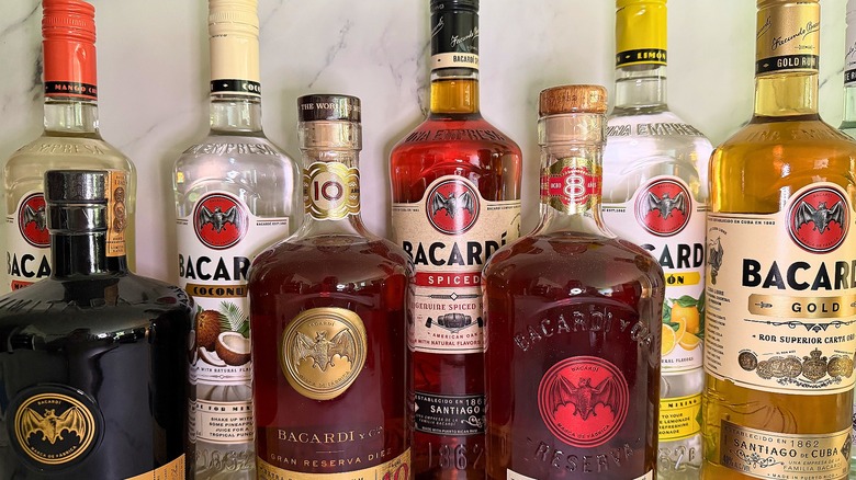 Several bottles of Bacardí rum lined up on marble background