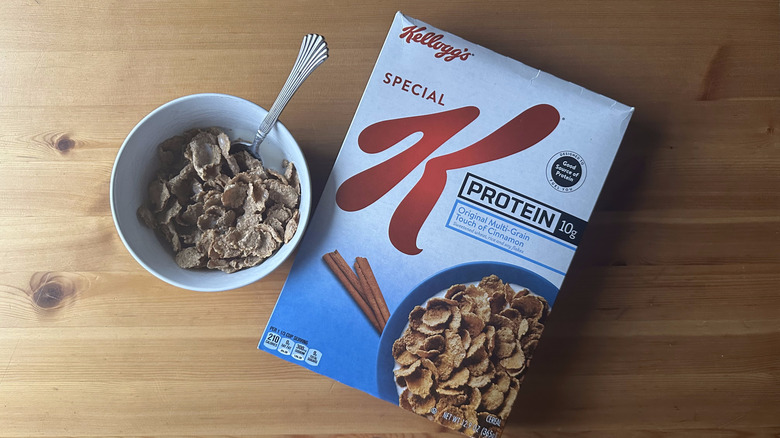 Special K Protein in white bowl on a wood table next to the cereal box.