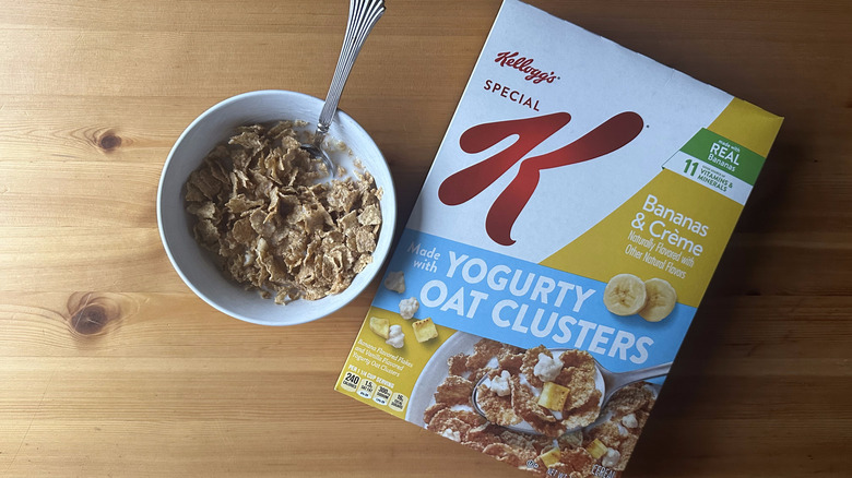 Bananas and Crème with Yogurty Oat Clusters Special K in white bowl on a wood table next to the cereal box.