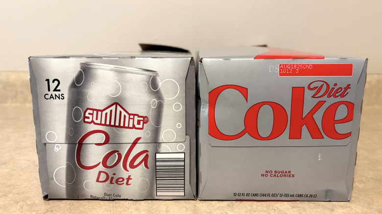 Diet Coke and Aldi Summit diet cola boxes on a neutral countertop