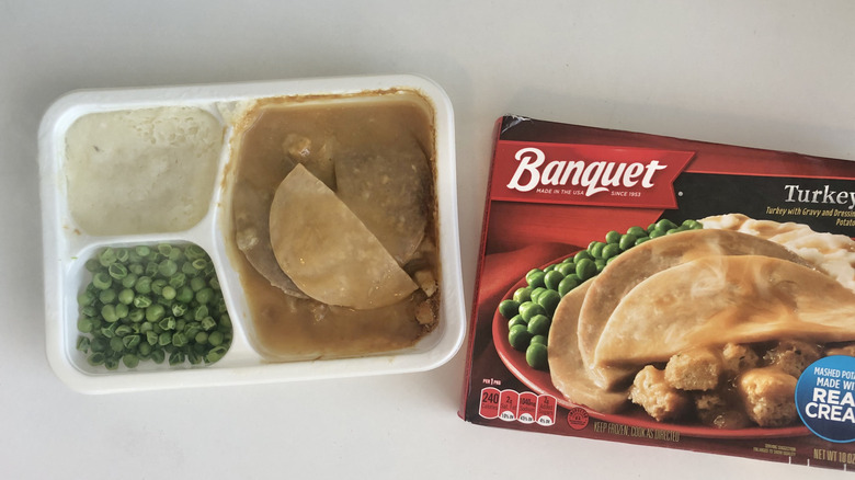 Banquet frozen turkey meal with mashed potatoes and peas.