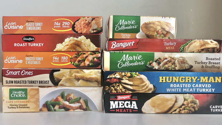 10 different frozen turkey dinners stacked in their boxes.
