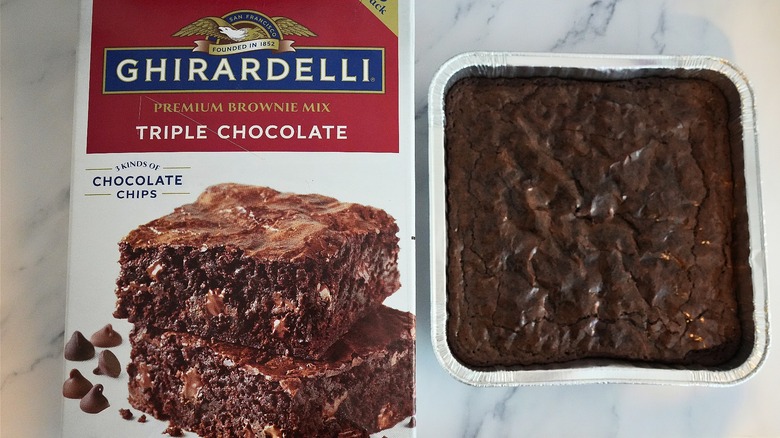 Ghirardelli Triple Chocolate Brownies in pan next to box on marble surface