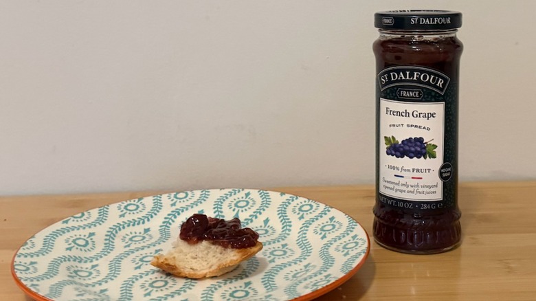 jar of St Dalfour grape fruit spread with a piece of bread and jelly on top