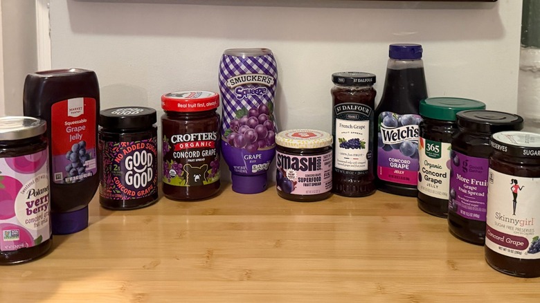 multiple types of grape jelly lined up on a table