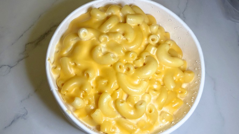 Walmart mac and cheese in container on marble surface