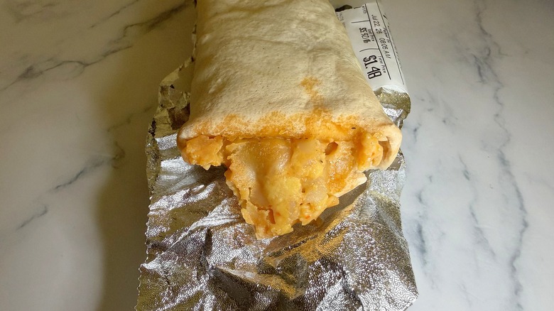 Walmart breakfast burrito on top of wrapper on marble surface