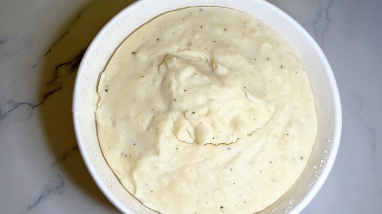 Walmart mashed potatoes in container on marble surface