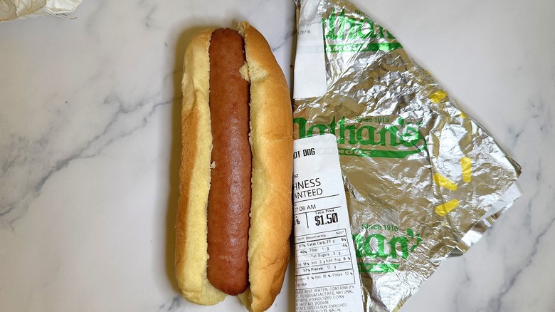 Walmart Nathan's deli hot dog next to wrapper on marble surface