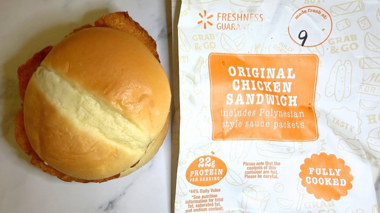 Walmart original chicken sandwich next to wrapper on marble surface