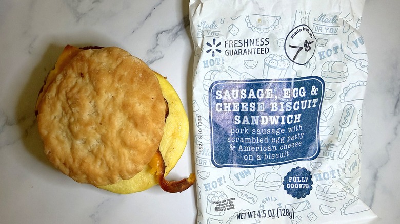 Walmart Sausage, Egg & Cheese Biscuit sandwich next to wrapper on marble surface
