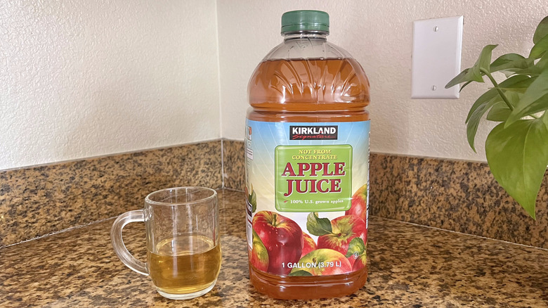 Glass of Kirkland apple juice next to the jug