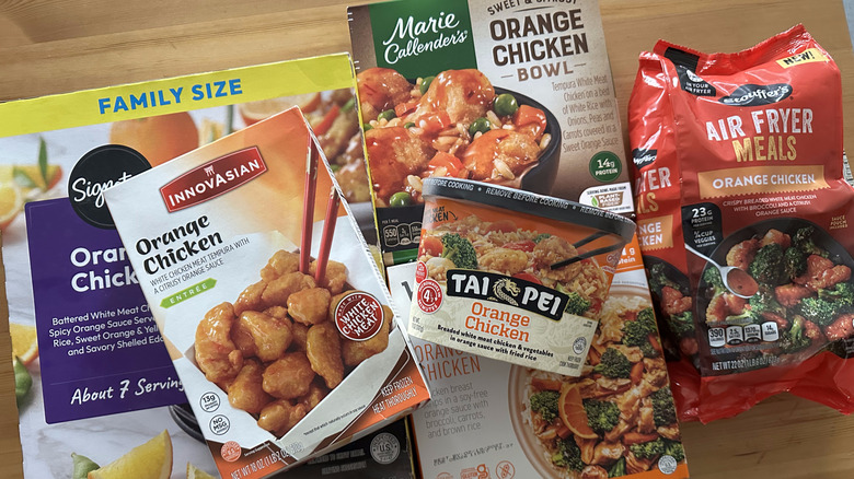 Frozen orange chicken dishes on wooden table