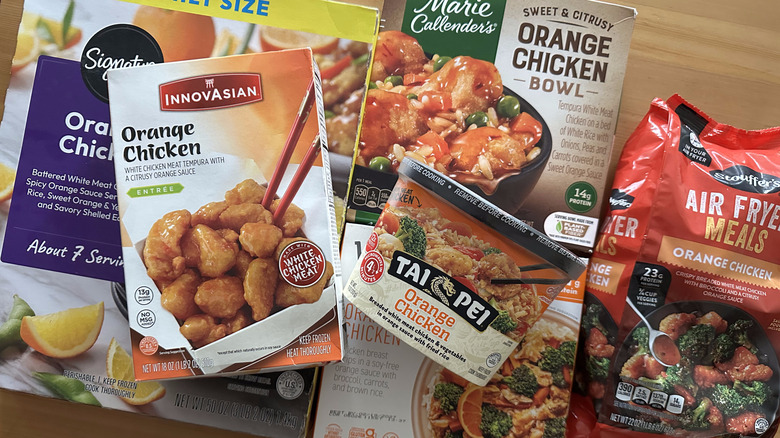 Frozen orange chicken dishes on wooden table