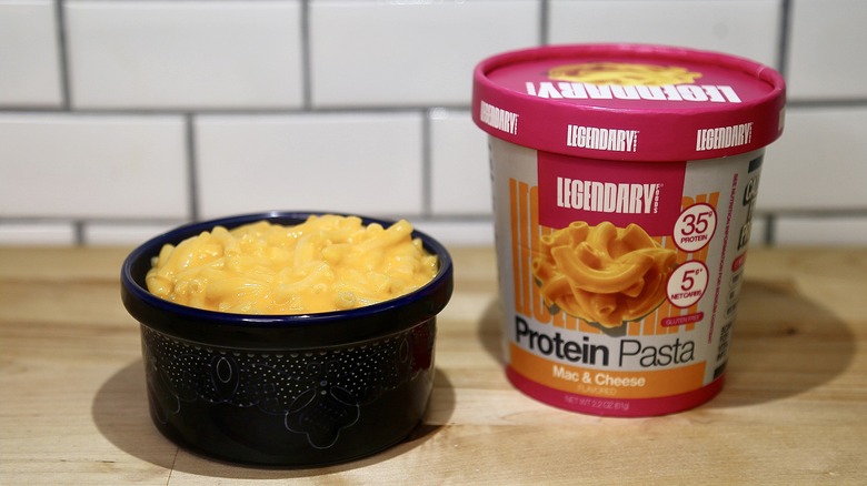 Legendary cup of mach and cheese with a bowl of mac and cheese on the side