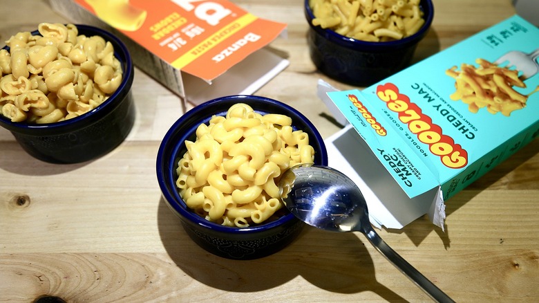 Bowls of mac and cheese with spoon and boxes