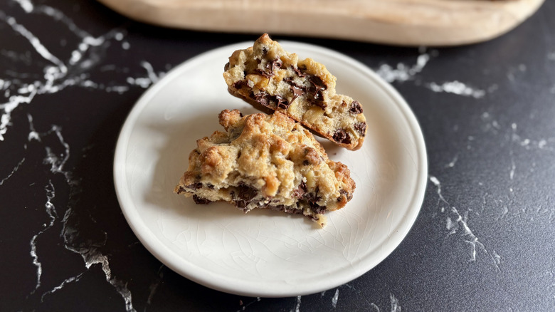 Levain chocolate chip walnut cookie split in half on plate