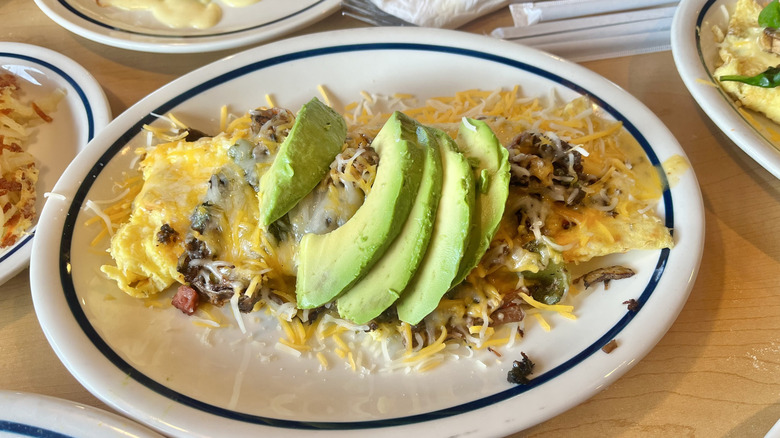 IHOP Spicy Poblano Omelette on a plate topped with freshly sliced avocado