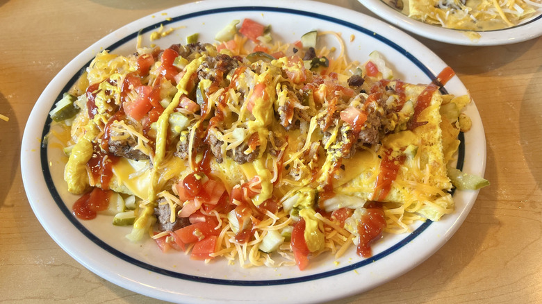 Close up of Cheeseburger Omelette at IHOP covered in cheese and drizzled with sauces