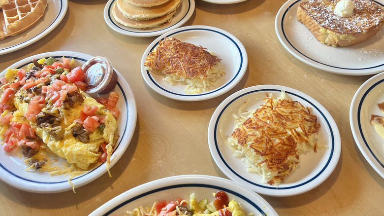 Top view of various IHOP foods on a table served on plates on top a wooden table