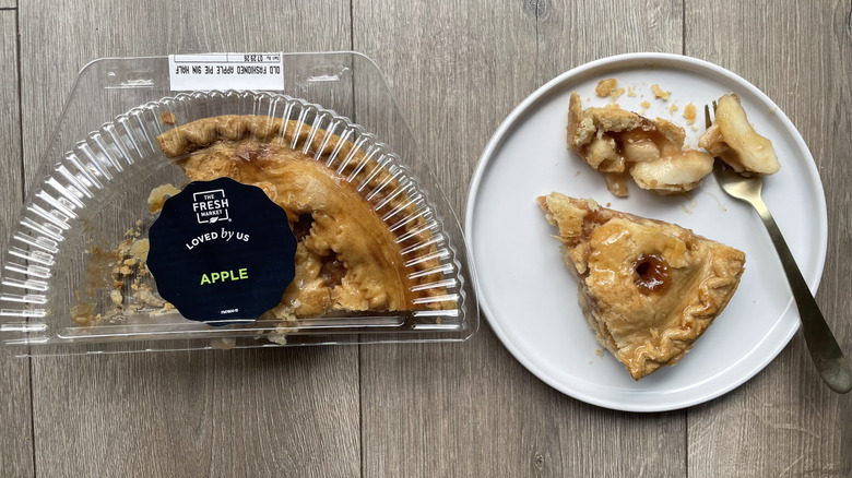 Fresh market apple pie in container and with slices pulled out on a plate
