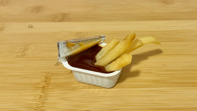McDonald's packet of barbecue sauce with fries dipped in it