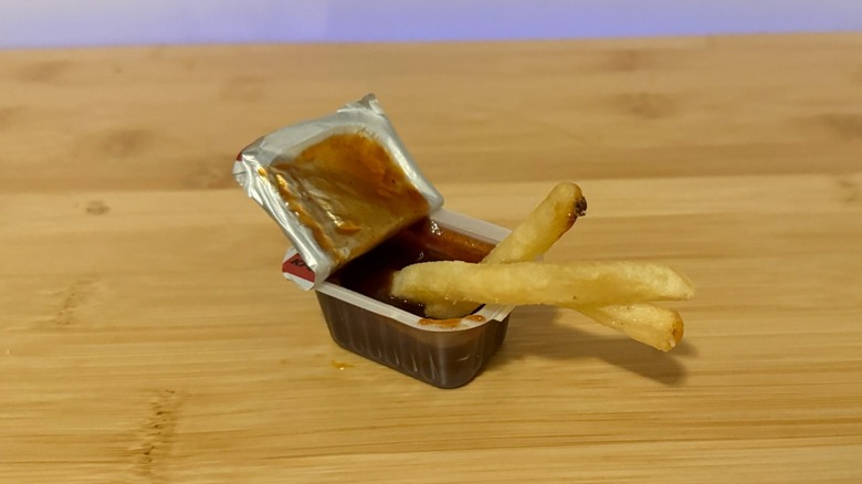 container of Wendy's barbecue sauce with french fries dipped in it