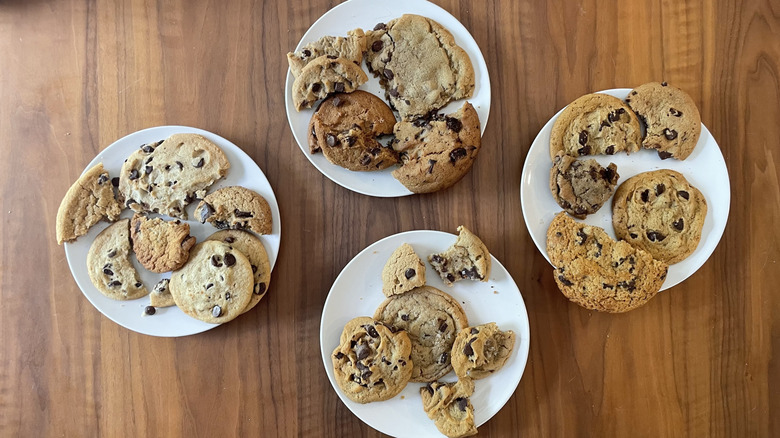 Assorted chocolate chip cookies on four plates