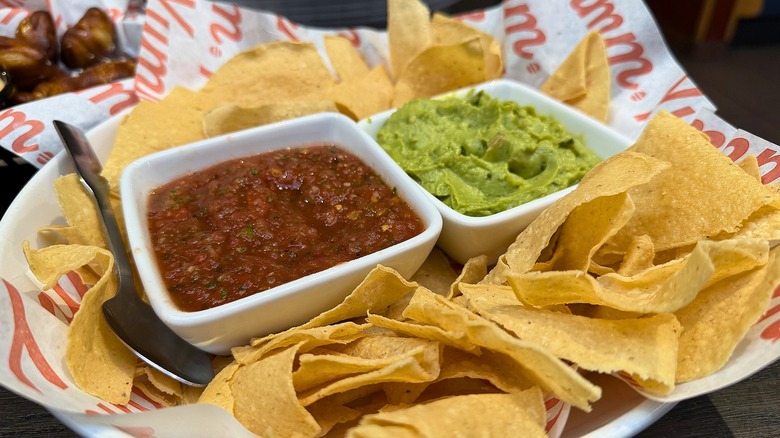 Chips, guac, and salsa in Red Robin basket on table