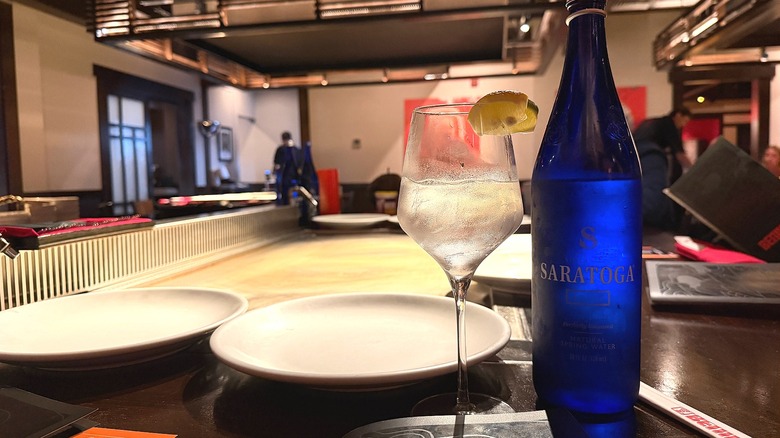 Water bottle and glass in front of empty plates, empty grill at Benihana