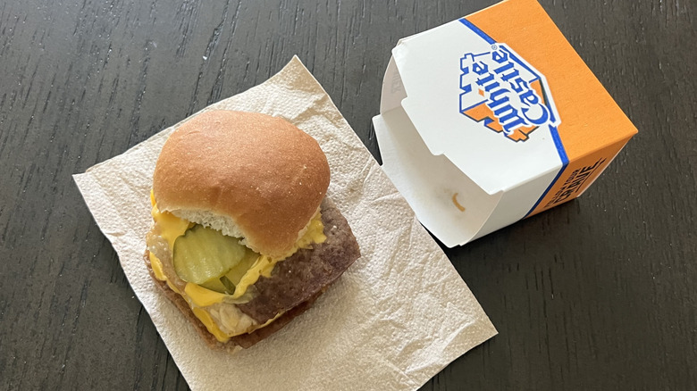 White Castle slider box with double cheese slider placed on a napkin showing what's inside
