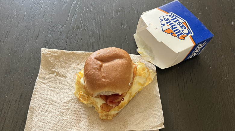 White Castle bacon breakfast slider on a napkin with a box