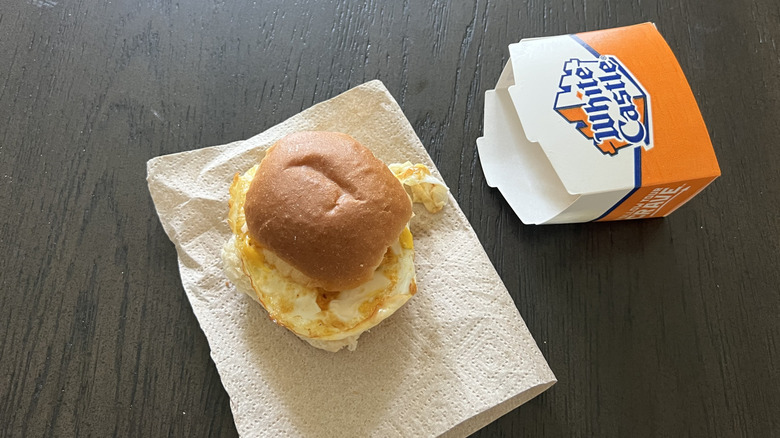 White Castle bun, egg, and cheese slider on a napkin with a box on the side