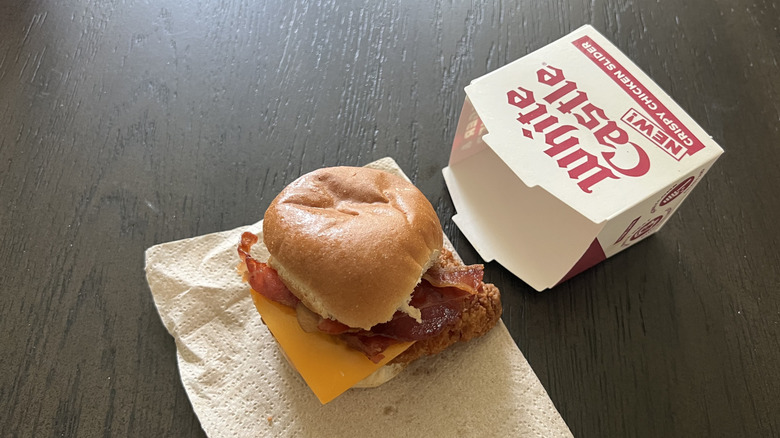 White Castle bacon and cheese chicken slider placed on a napkin on a dark table