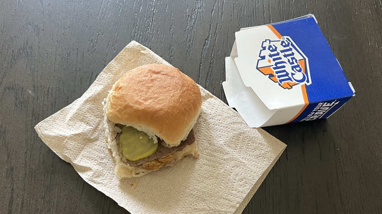 White Castle original slider placed on a napkin with a box next to it