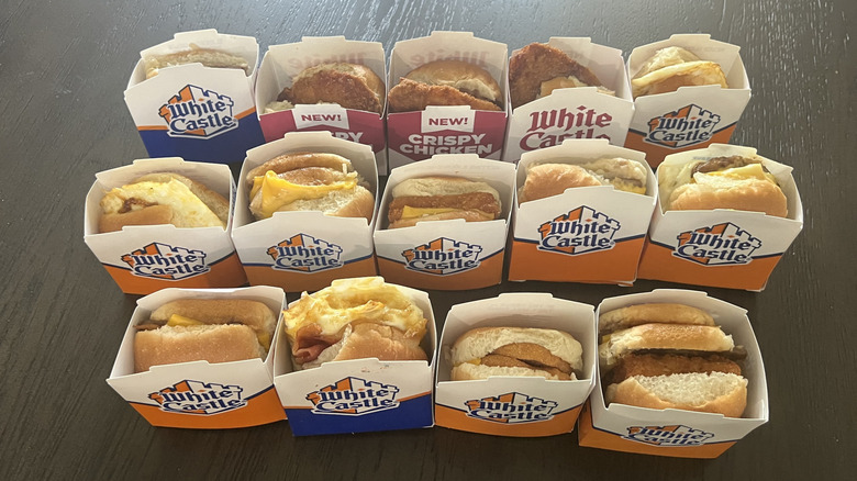 Every single White Castle slider in to-go boxes laid on a dark table