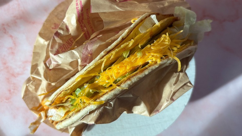 Close-up of Taco Bell Volcano Cheesy Gordita on pink background