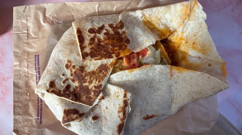 Close-up of Taco Bell Volcano Crunchwrap on pink background