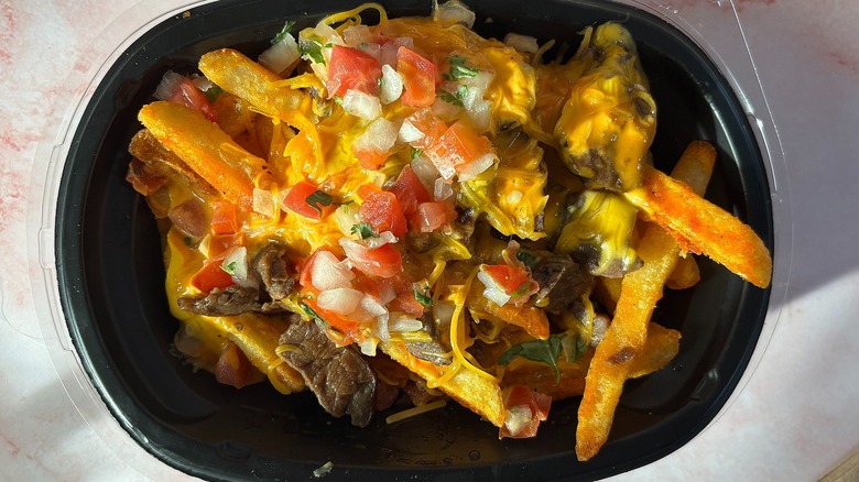 Close-up of Taco Bell Volcano Steak Fries on pink background