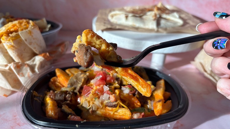 Close-up of Taco Bell Volcano steak fries on pink background