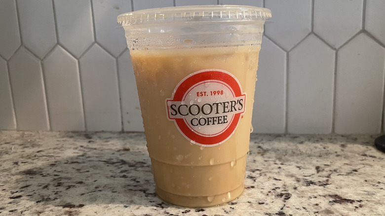 Scooter's iced latte in a plastic to go cup on a granite countertop