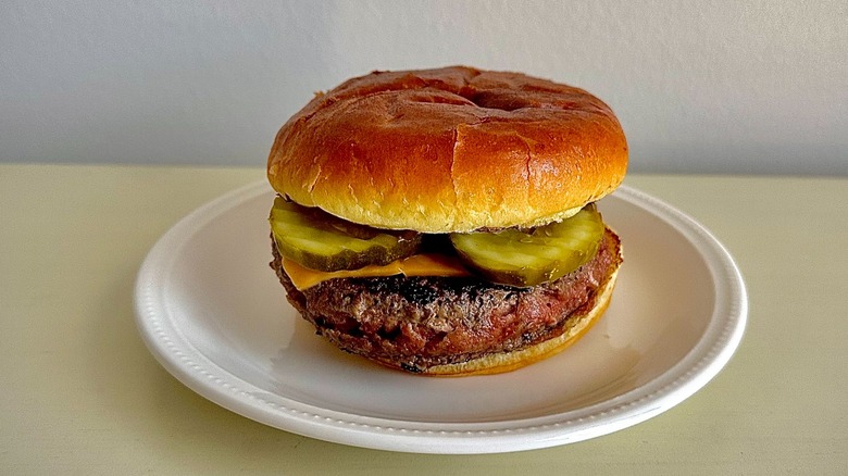 Outback Steakhouse's cheeseburger on a small white plate in front of a neutral background